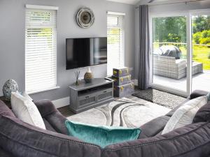 a living room with a couch and a television at Oak Park One - Uk50062 in Tiverton
