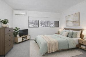 a bedroom with a bed and a television in it at Modern 2BR Apartment North Adelaide in North Adelaide