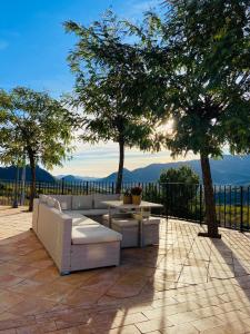 a patio with couches and a table and trees at Casa Romeriko piscina privada vistas espectaculares Valle de Ricote Murcia in Ricote