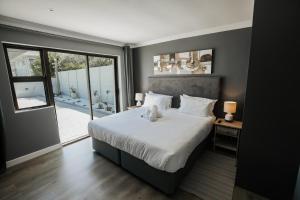 a bedroom with a large bed and a large window at Wave Inn Guesthouse in Valsbaai