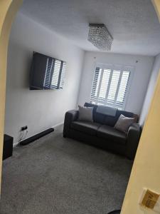 a living room with a couch and two windows at Flat 8 in Plymouth