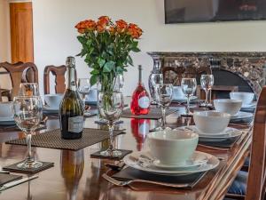 a table with a bottle of wine and a vase of flowers at Groudd Hall in Cerrigydrudion