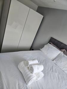 a white bed with two rolled towels on it at Flat 8 in Plymouth