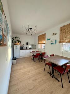 a dining room with tables and chairs and a kitchen at Pensión O Regato in Redondela
