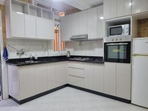 a kitchen with white cabinets and black counter tops at Appartement Imi-Ouaddar 2 in Agadir nʼ Aït Sa