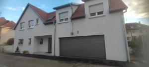 a white house with a garage at Chambres Strasbourg in Strasbourg