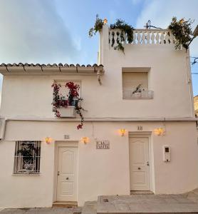 a white building with two doors and two windows at Las Casitas de Cullera Sol y Mar in Cullera