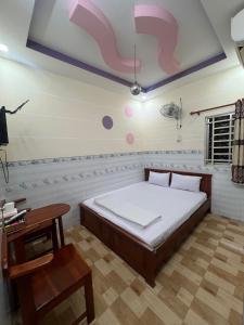 a bedroom with a large bed and a table at Nhà nghỉ Phú Mỹ in Ấp An Mỹ