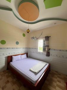 a bedroom with a bed in a room with a ceiling at Nhà nghỉ Phú Mỹ in Ấp An Mỹ