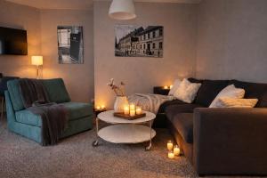 a living room with two couches and a table with candles at Haus Gitta - Stilvolle Stadtoase in Luckenwalde