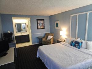 a hotel room with a bed and a chair at Hawk's Nest Lodge in Osage Beach