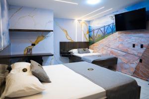 a room with two beds and a tv on the wall at Hotel Bacatá Isla in Bucaramanga