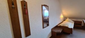 a small bedroom with a bed and a mirror at Pension Hauber - Hotzenwaldblick in Herrischried