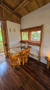 a dining room with a wooden table and chairs at Cabaña Mirador Calima in Mediacanoa