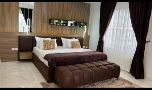 a bedroom with a large bed with a brown tufted headboard at Luxury 3Bedroom Apartment in Sangotedo Ajah in Lekki