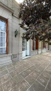 a building with white doors and windows and a sidewalk at V.60 in Nueve de Julio