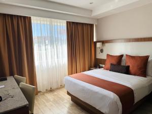 ein Hotelzimmer mit Bett, Schreibtisch und Fenster in der Unterkunft Hotel Soleil Business Class in León