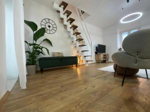 a living room with stairs and a couch and a chair at St Peter's Heritage House in Trogir