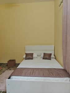 a bedroom with a white bed with two pillows at Tataicha Appart 3 in NʼDjamena +12 photos