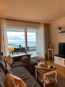 a living room with a couch and a view of the ocean at StrandSUITE Scharbeutz Meerblick in Scharbeutz