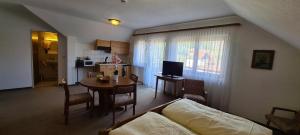 a living room with a couch and a table and a kitchen at Pension Hauber - Kirchturmblick in Herrischried