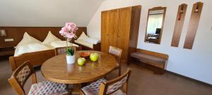 a room with a table and a bedroom with a bed at Pension Hauber - Kirchturmblick in Herrischried