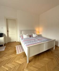 a bedroom with a large bed with a wooden floor at Panoráma apartmán Centrum in Banská Štiavnica