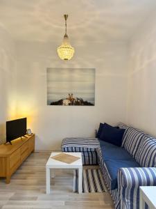 a living room with a blue couch and a table at Panoráma apartmán Centrum in Banská Štiavnica