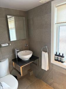 a bathroom with a sink and a toilet and a mirror at Waterside House B&B in Ullapool