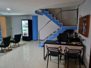 a lobby with a staircase with chairs and a table at Hostel Way Fortaleza in Fortaleza