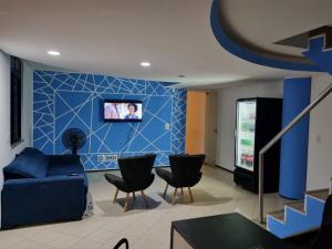 a living room with a couch and a blue wall at Hostel Way Fortaleza in Fortaleza