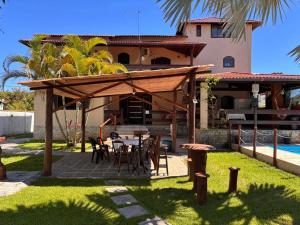 a patio with a table and chairs in front of a house at Casa Barra Mar in Saquarema