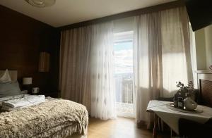 a bedroom with a bed and a large window at Gästehaus 3-Länderblick-Panoramablick in Mönichkirchen