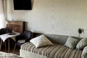 a living room with a couch and a table at Gästehaus 3-Länderblick-Panoramablick in Mönichkirchen