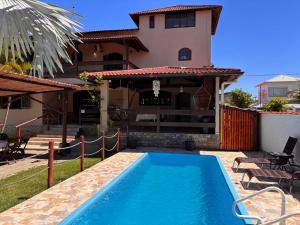 a swimming pool in front of a house at Casa Barra Mar in Saquarema