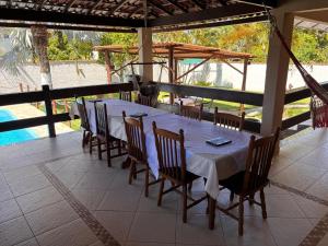 a dining table and chairs on a patio with a pool at Casa Barra Mar in Saquarema