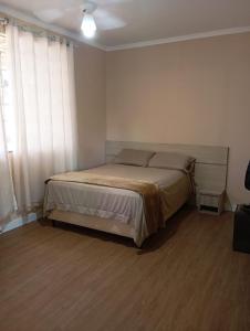 a bedroom with a bed and a large window at Casa da Colina Curitiba com piscina in Curitiba +25 photos