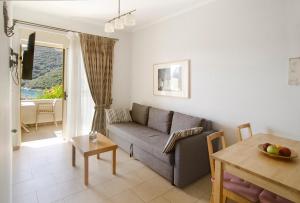 a living room with a couch and a table at Rouda Village in Mikros Gialos