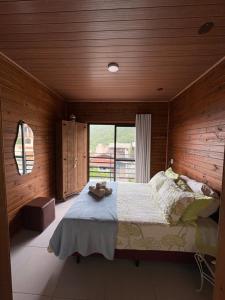 a bedroom with a large bed with wooden walls at Cobertura Vista mar com churrasqueira in Governador Celso Ramos