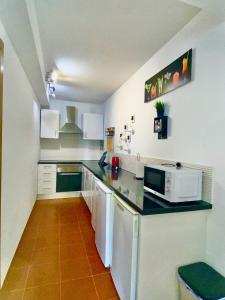 a kitchen with a counter top with a microwave at Atlantic Breeze House I Double Rooms at EL CAMPANARIO I 5 minutes from Popcorn Beach in Corralejo