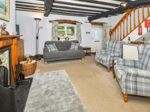 a living room with a couch and chairs and a fireplace at Osprey Cottage in Bassenthwaite