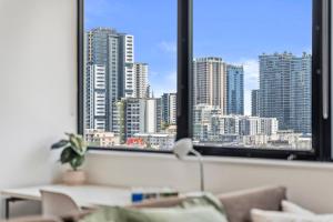 a living room with a view of a city from a window at Riverview Sanctuary - Walk to CBD & South Bank in Brisbane
