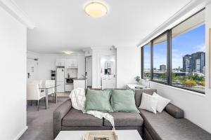 a living room with a couch and a large window at Riverview Sanctuary - Walk to CBD & South Bank in Brisbane