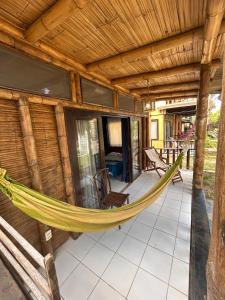 a hammock on the porch of a house at Punta Pacífico Bungalows Máncora in Máncora