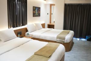 a hotel room with two beds and a window at Hotel Nature's Nest in Shirdi