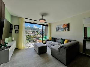 a living room with a couch and a large window at Avitat Link in San Salvador