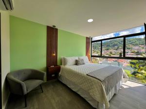 a bedroom with a bed and a chair and a window at Avitat Link in San Salvador +12 photos