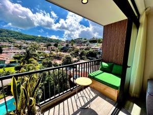 a balcony with a green bench and a view of a city at Avitat Link in San Salvador