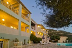 a large building with a swimming pool in front of it at Rouda Village in Mikros Gialos