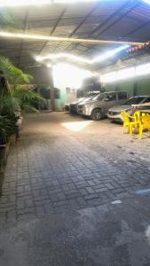 a parking garage with parked cars and yellow tables and chairs at Flat Equipado no Centro - Conforto in Governador Valadares